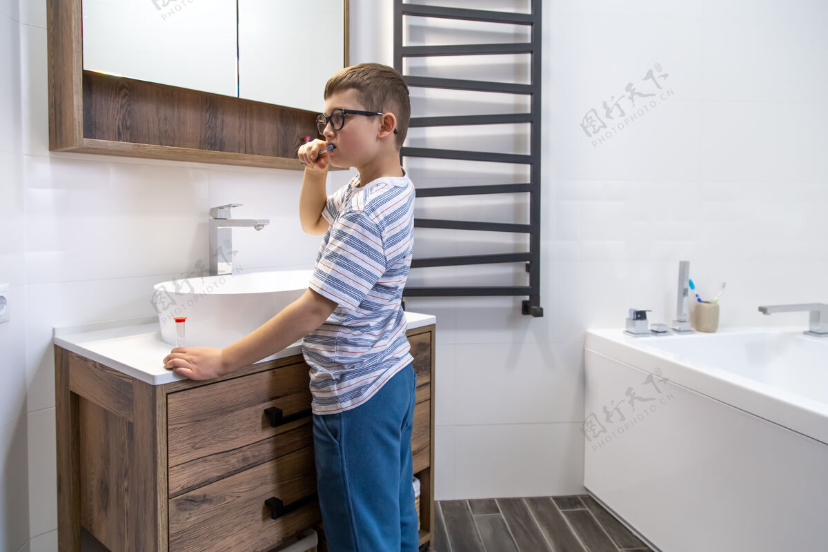 保持一个可爱的小男孩刷牙 用沙漏计时卫生时间清洁