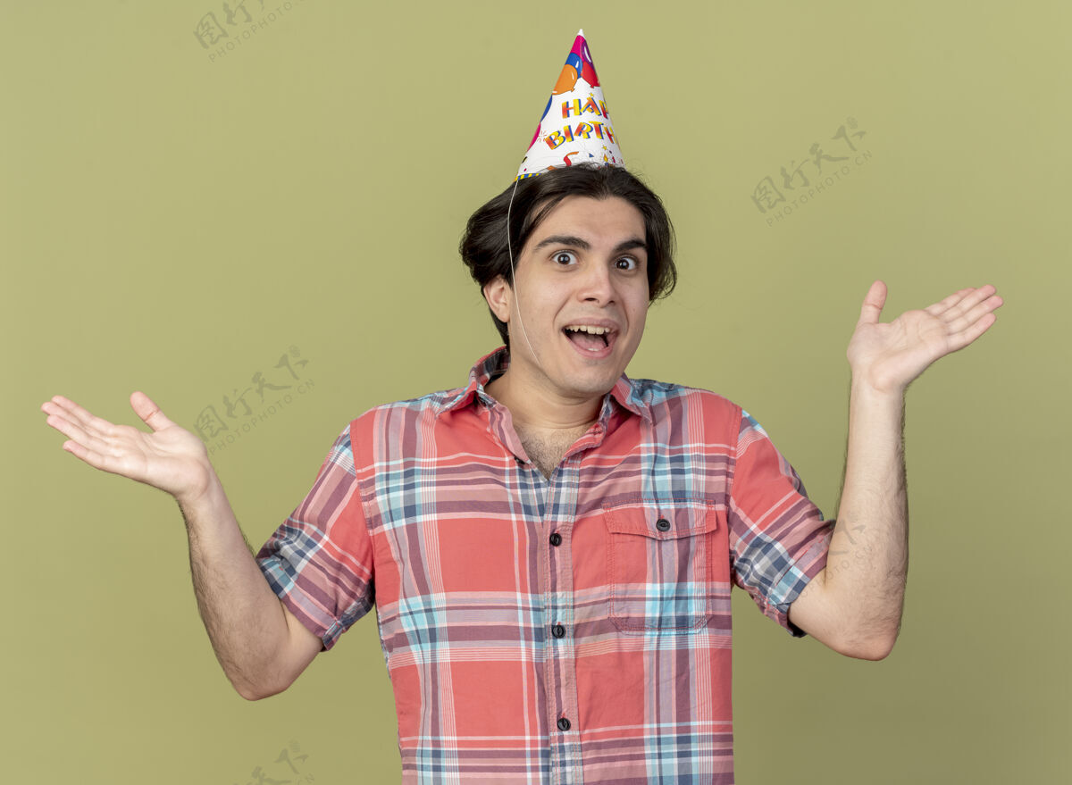 橄榄快乐英俊的白人男子戴着生日帽站着 双手张开帅哥男人穿