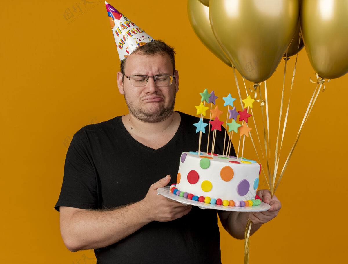 氦失望的成年斯拉夫人戴着眼镜 戴着生日帽 手里拿着氦气球和生日蛋糕眼镜复制斯拉夫