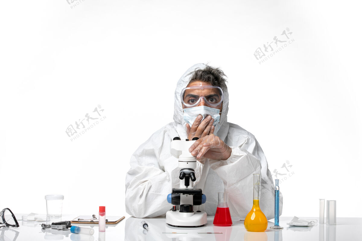 医生男医生穿着防护服 戴着口罩 用显微镜观察浅白色健康使用面罩
