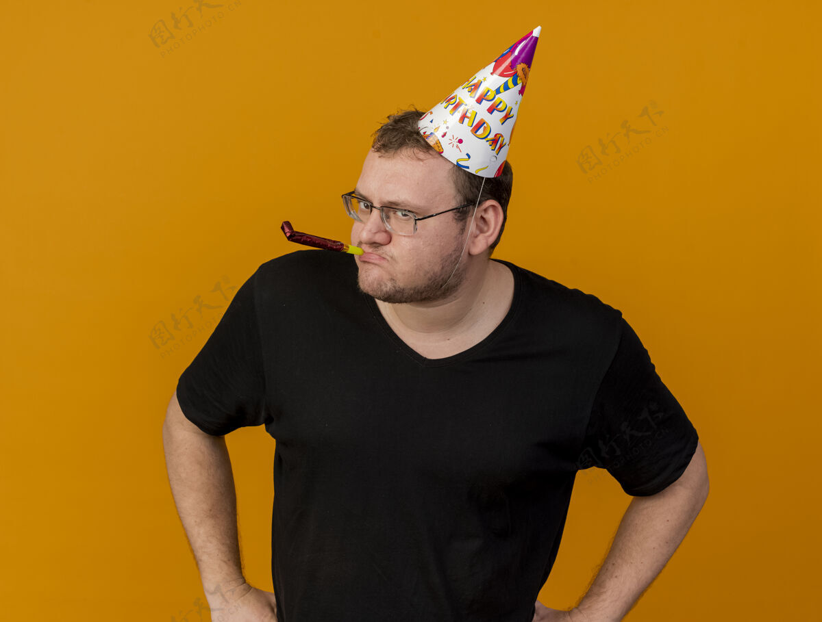 复制自信的成年斯拉夫人戴着眼镜戴着生日帽吹着派对口哨聚会成人吹