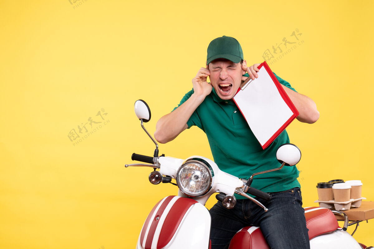 送货正面图身穿绿色制服的年轻男信使拿着黄色的文件纸条货舱文件工作