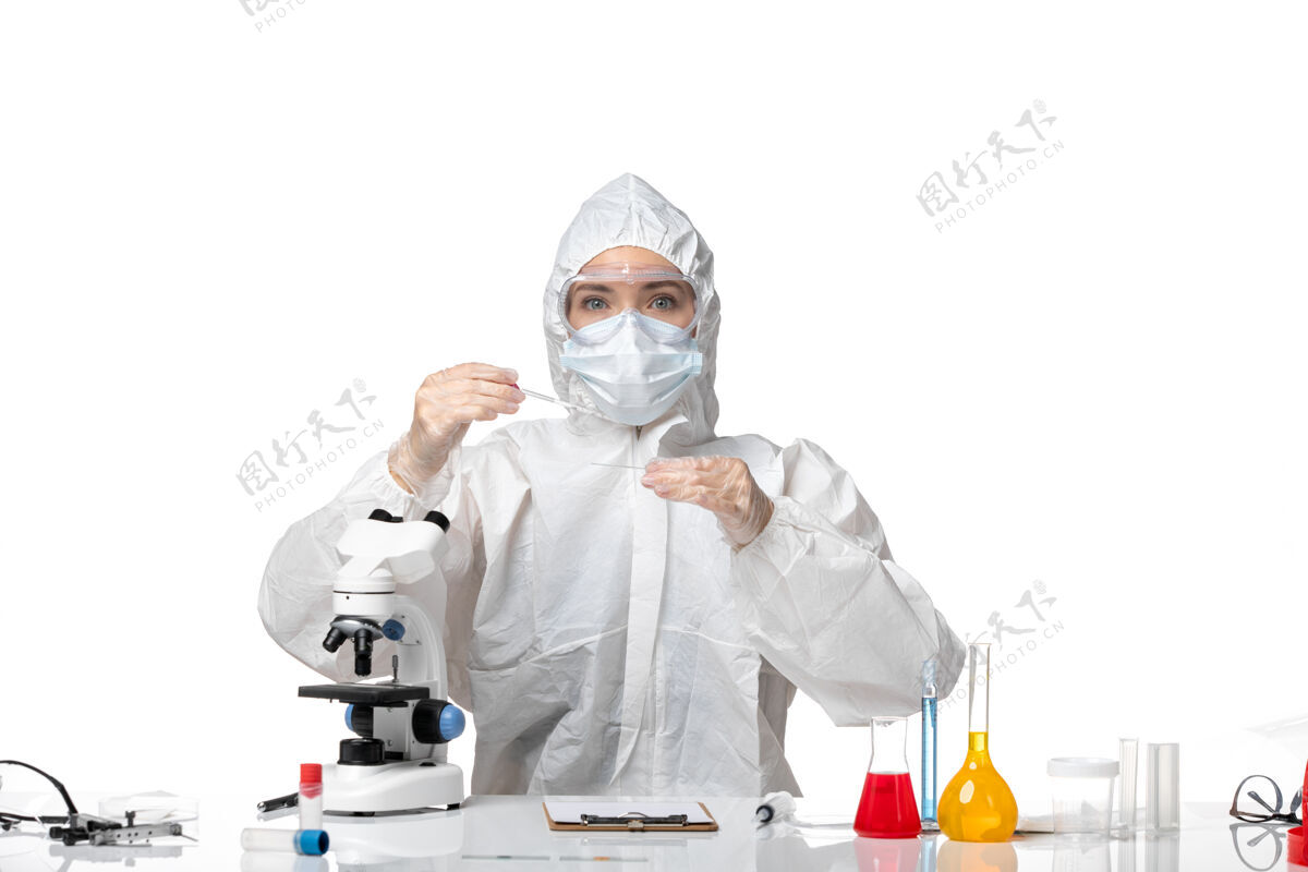 医生正面图年轻女医生穿着白色防护服 戴着口罩 因为covid在浅白背景上工作 大流行性飞溅病毒covid-病毒大流行工作