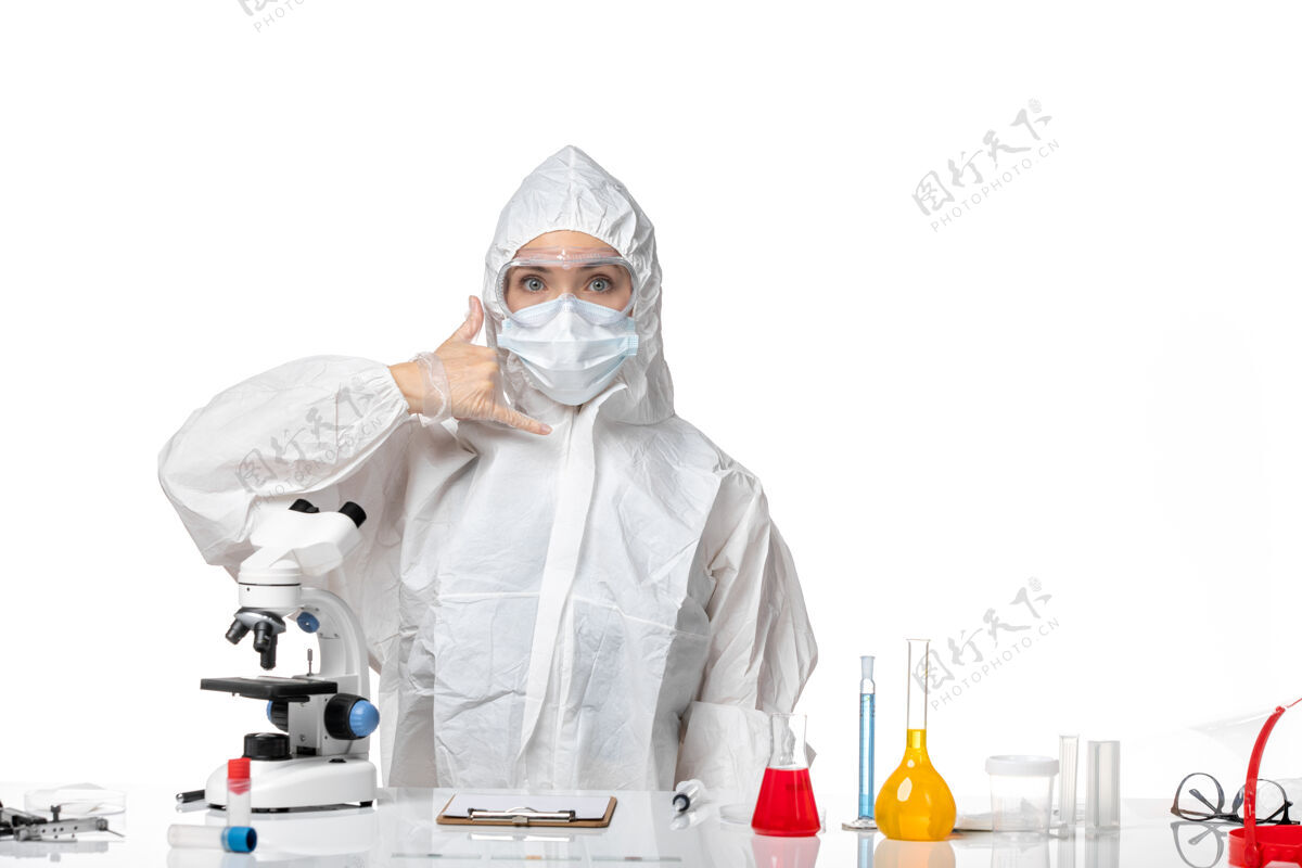 医生正面图年轻女医生穿着白色防护服 戴着口罩 因为科维德在白色办公桌上摆姿势病毒大流行飞溅科维德医学医学面具