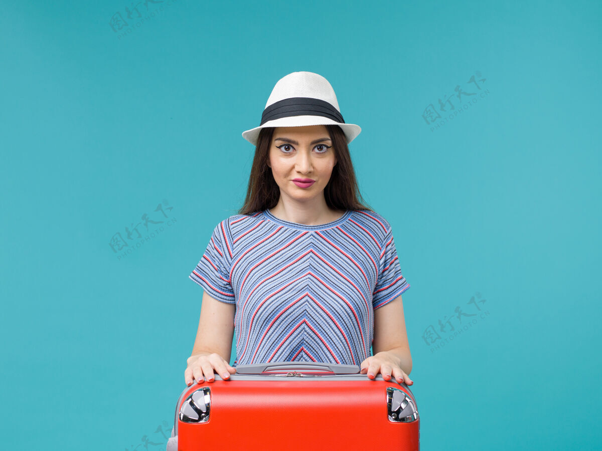 享受前视图带着红包的度假妇女在蓝色背景上享受她的旅行旅行旅行旅行度假女性旅行人包旅行