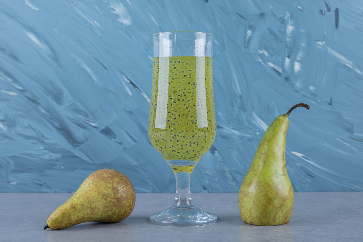 配料灰色表面上新鲜梨和果汁的特写镜头素食自然健康