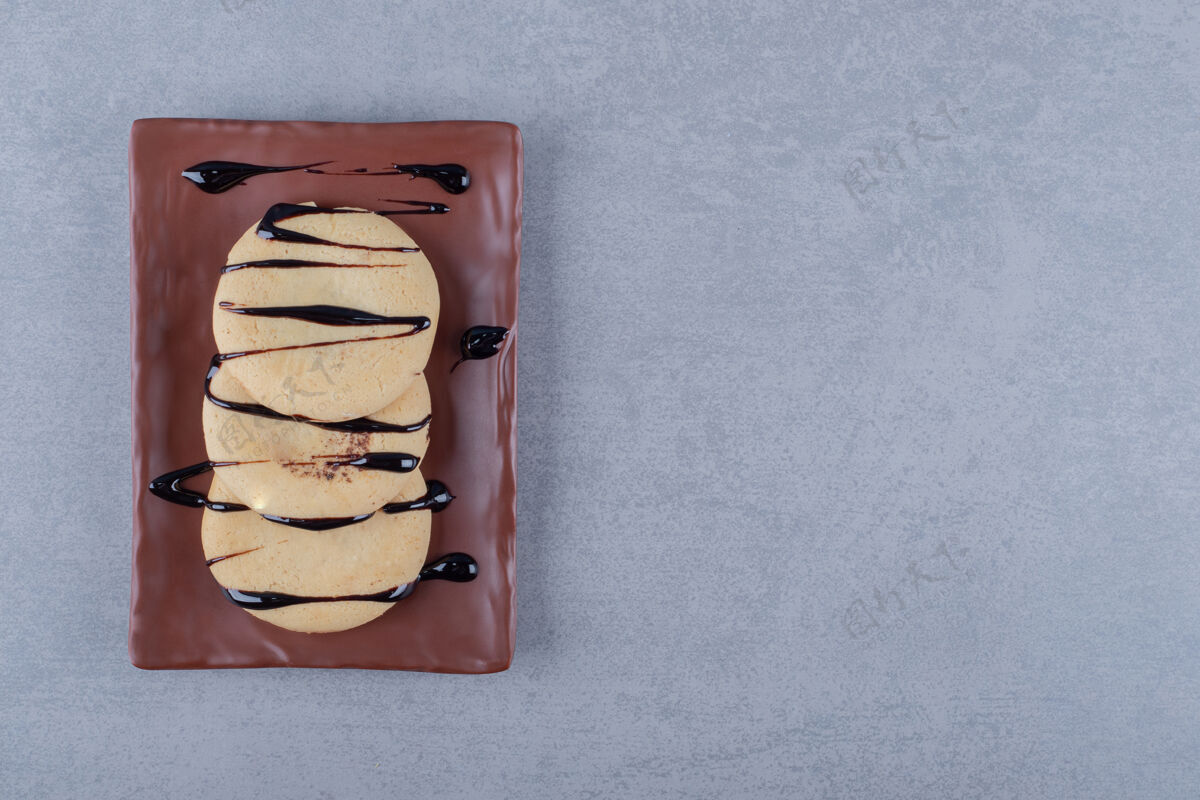 烘焙食品棕色盘子上有巧克力酱的新鲜饼干自制烘焙糖