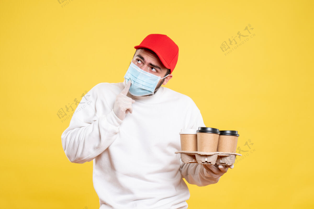成人戴着面具的男信使拿着黄色的咖啡送货男性信使医生