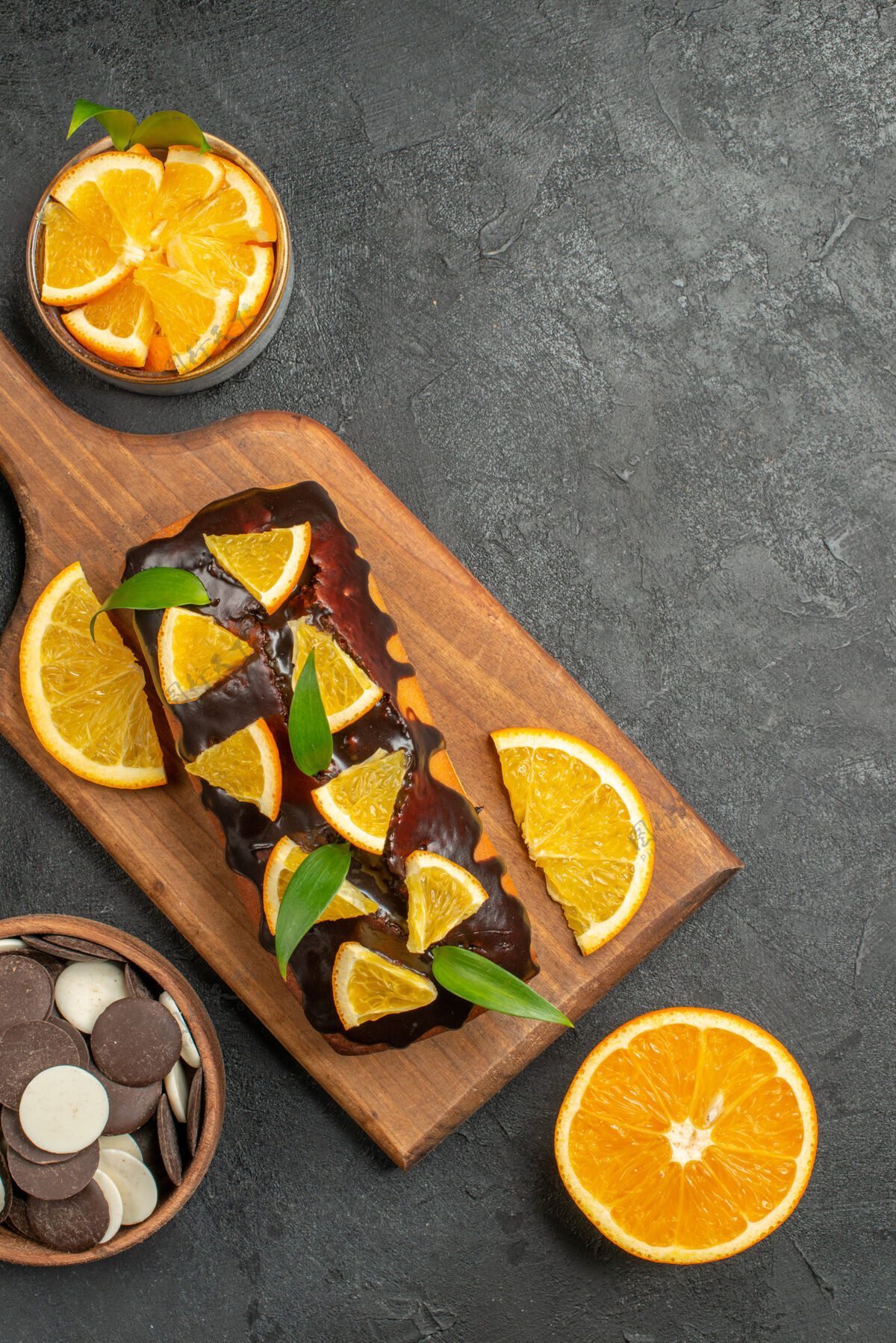 深色美味蛋糕的垂直视图在深色桌子上的砧板上切柠檬和饼干健康餐桌食物