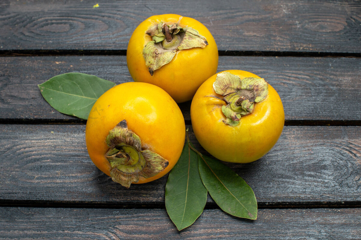 素食正面是新鲜甜甜的柿子 放在木质质朴的书桌上 水果醇香的树上有机饮食树
