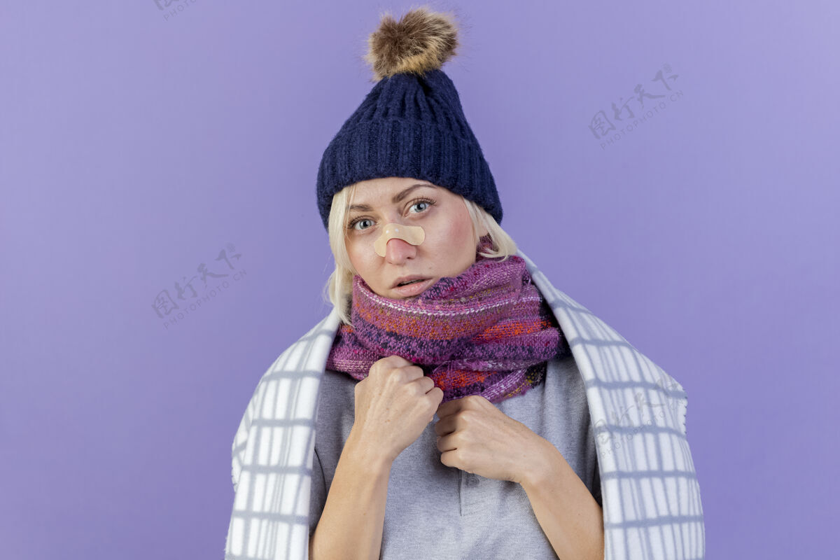 帽子自信的年轻金发病斯拉夫女人鼻子上贴着医用膏药戴着冬天的帽子和围巾格子金发年轻