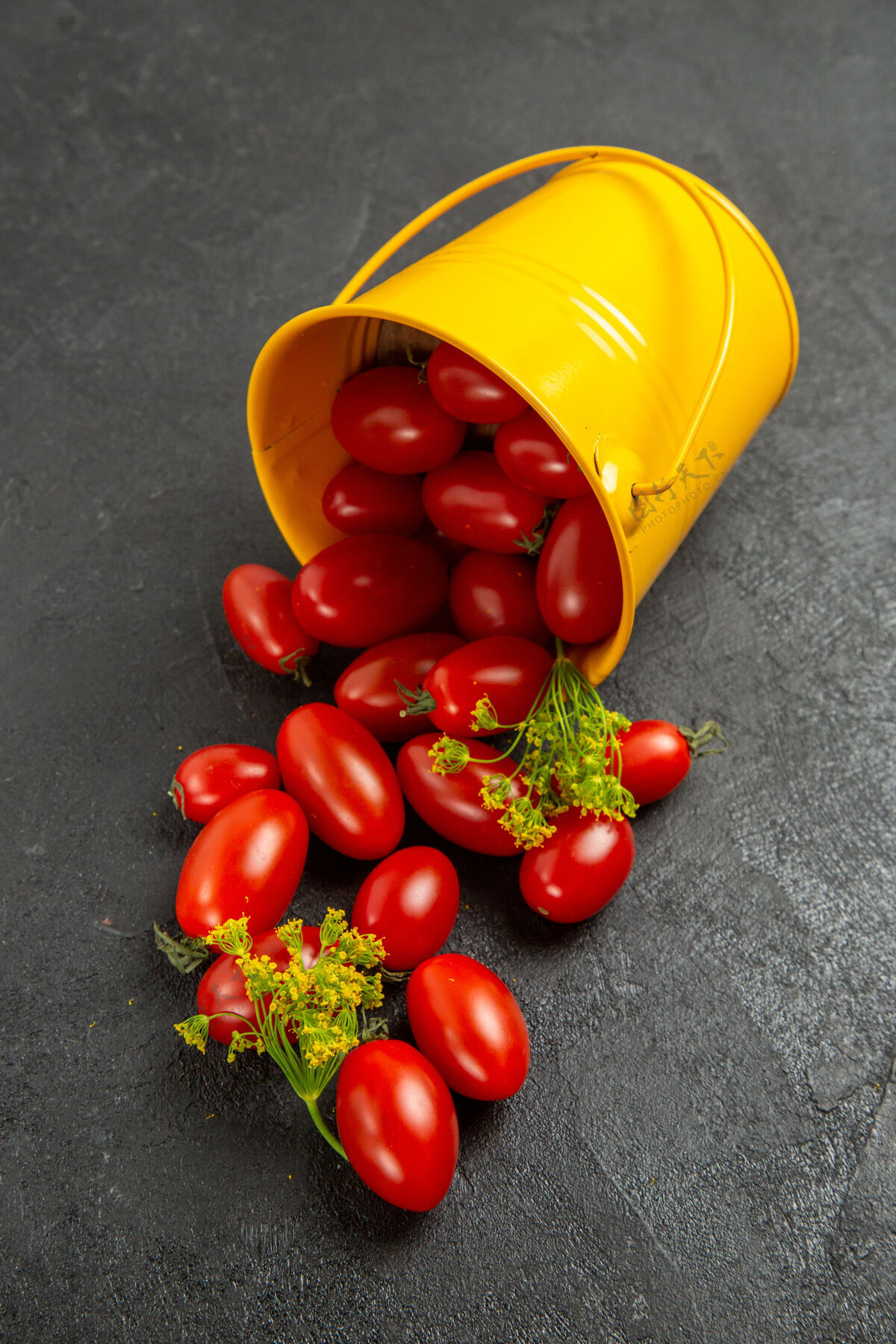磨碎俯视图：黑暗的地面上 黄色的桶里装满了樱桃番茄和莳萝花蔬菜食品胡椒