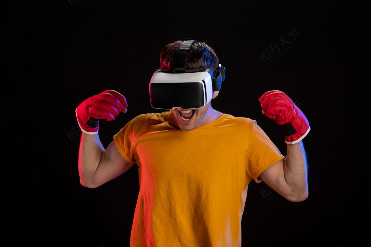 视觉在黑暗的表面上戴着mma手套玩虚拟现实的年轻男性年轻男性现实男性
