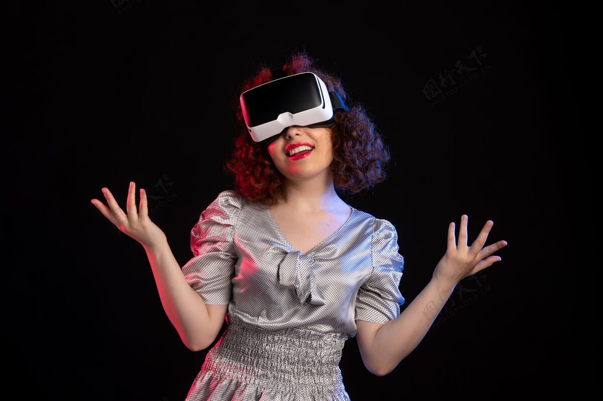 成人美丽的女性戴着虚拟现实耳机在黑暗的表面女人视觉女性
