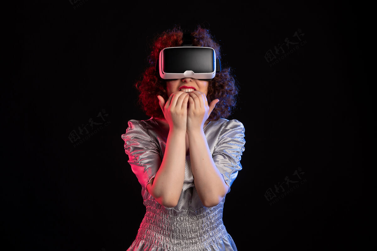 游戏年轻女性戴着虚拟现实耳机在黑暗的表面肖像视觉耳机