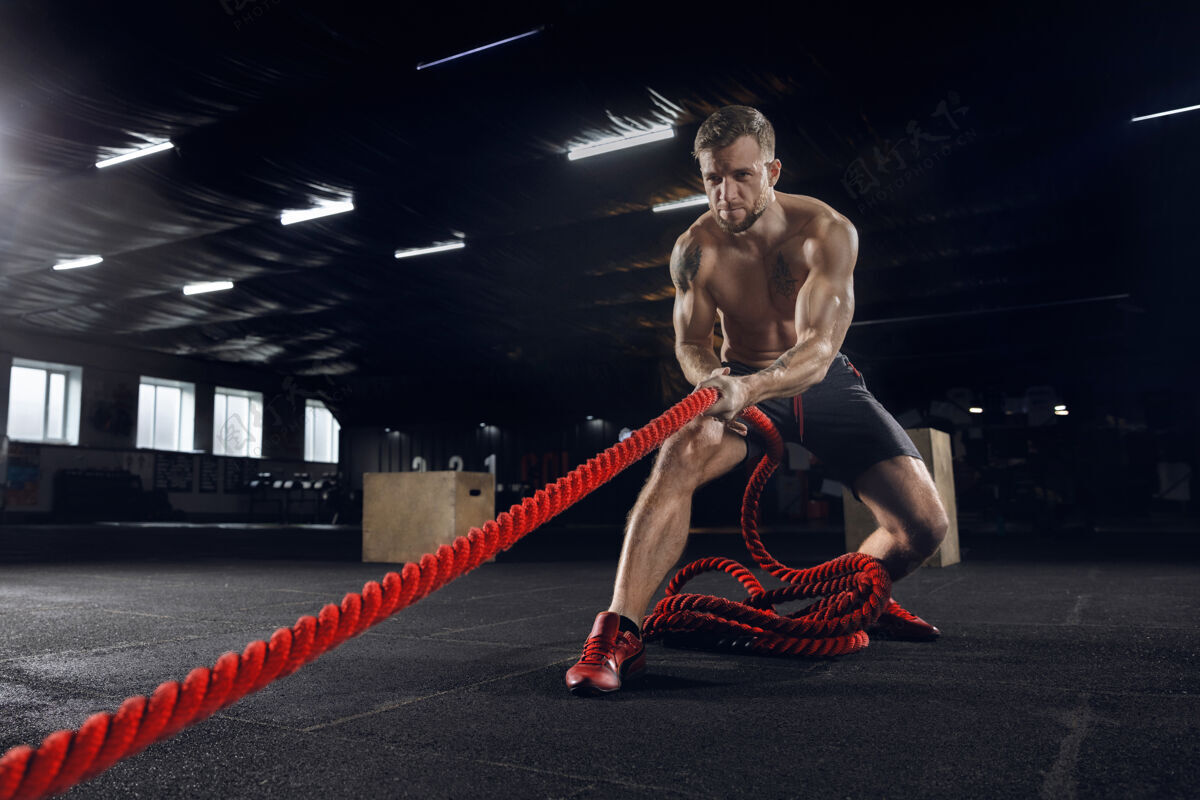 肌肉年轻健康的人 在体育馆里用绳子锻炼的运动员交叉教练站立