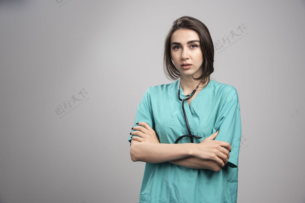 治疗带听诊器的女医生站在灰色背景上高质量照片女性成人医生