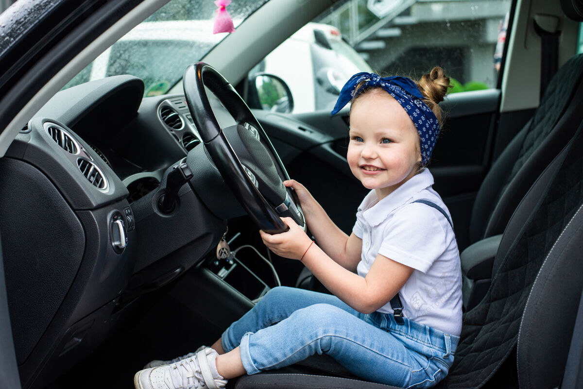 小女孩一个小女孩假装开车孩子的教育理念 学习 开车 搞笑 快乐 玩耍 快乐 汽车保险女孩孩子学习