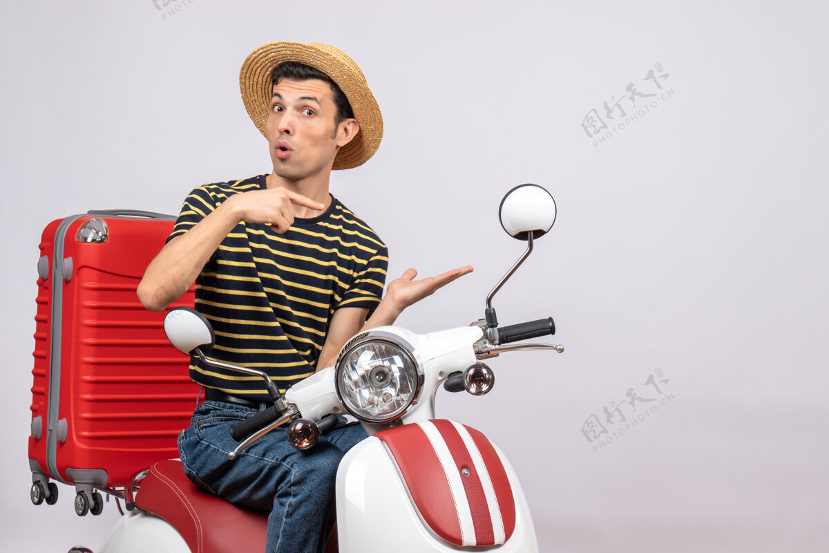 前面一个戴着草帽的年轻人正指着他的手指向手摩托车