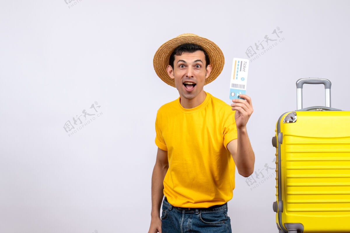 帽子正面图年轻游客手持机票站在手提箱旁风景微笑男