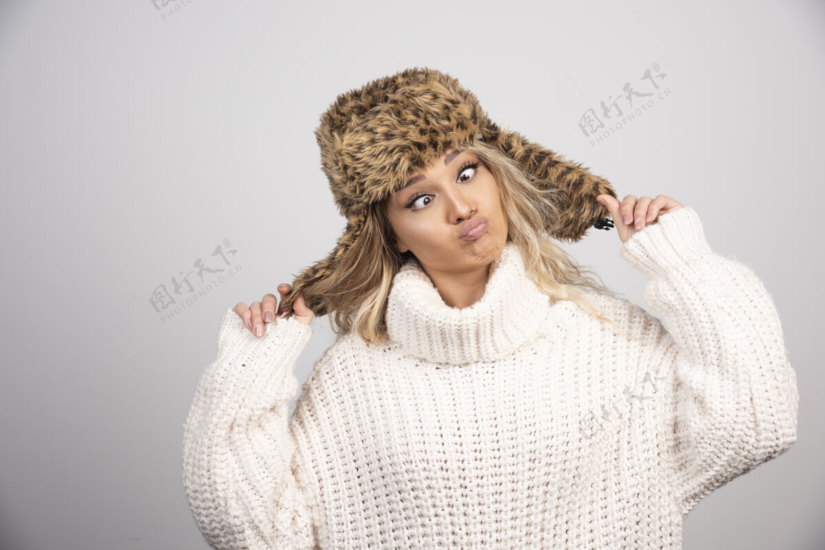 白色戴着冬帽的女人做着俏皮的脸休闲毛衣女士