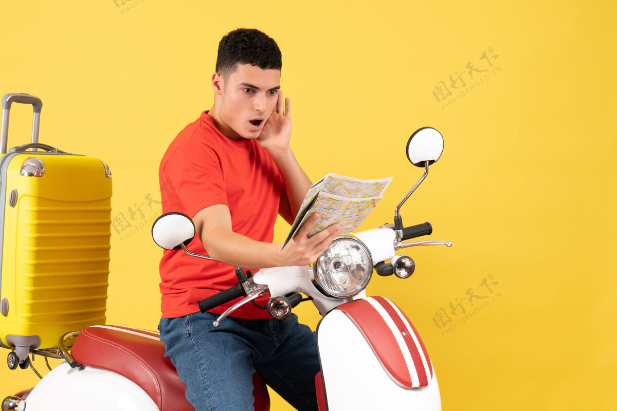人前视图：骑着轻便摩托车的年轻人在看地图视图健身男性