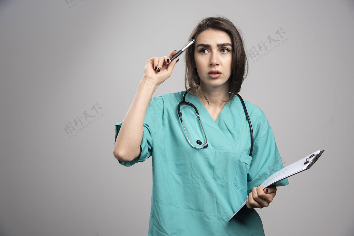 妇女带着剪贴板思考手术的女医生高质量照片女性检查医生