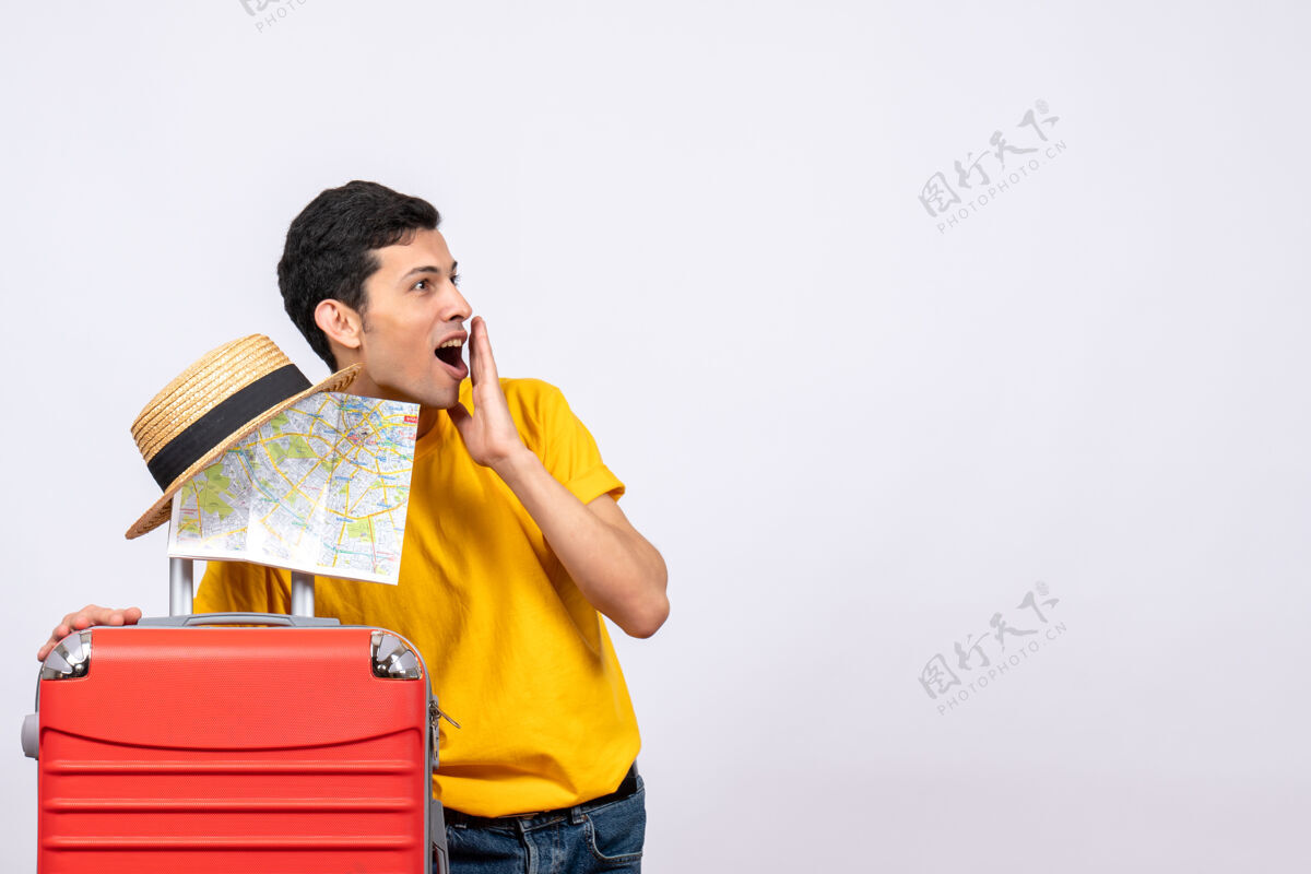 站立正面图：一个穿着黄色t恤的年轻人拿着草帽和地图帽子男人地图