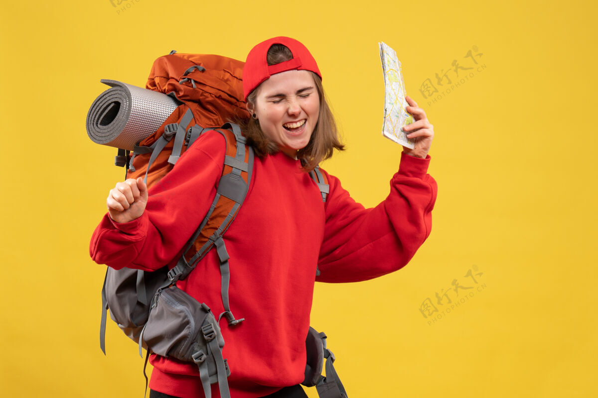 地图前视图高兴的女徒步旅行者与红色背包举行地图成人前面拿着