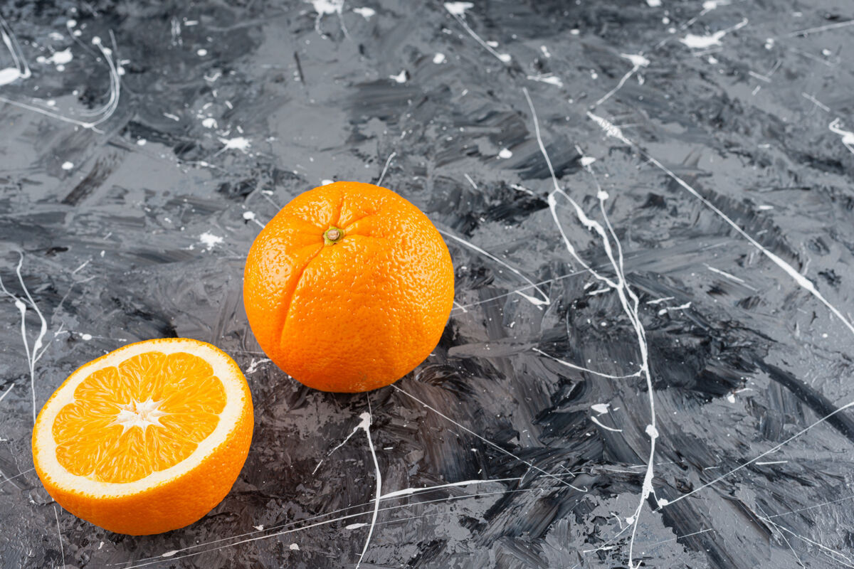 成熟把整个成熟的橙子切片放在大理石表面上切片有机美味