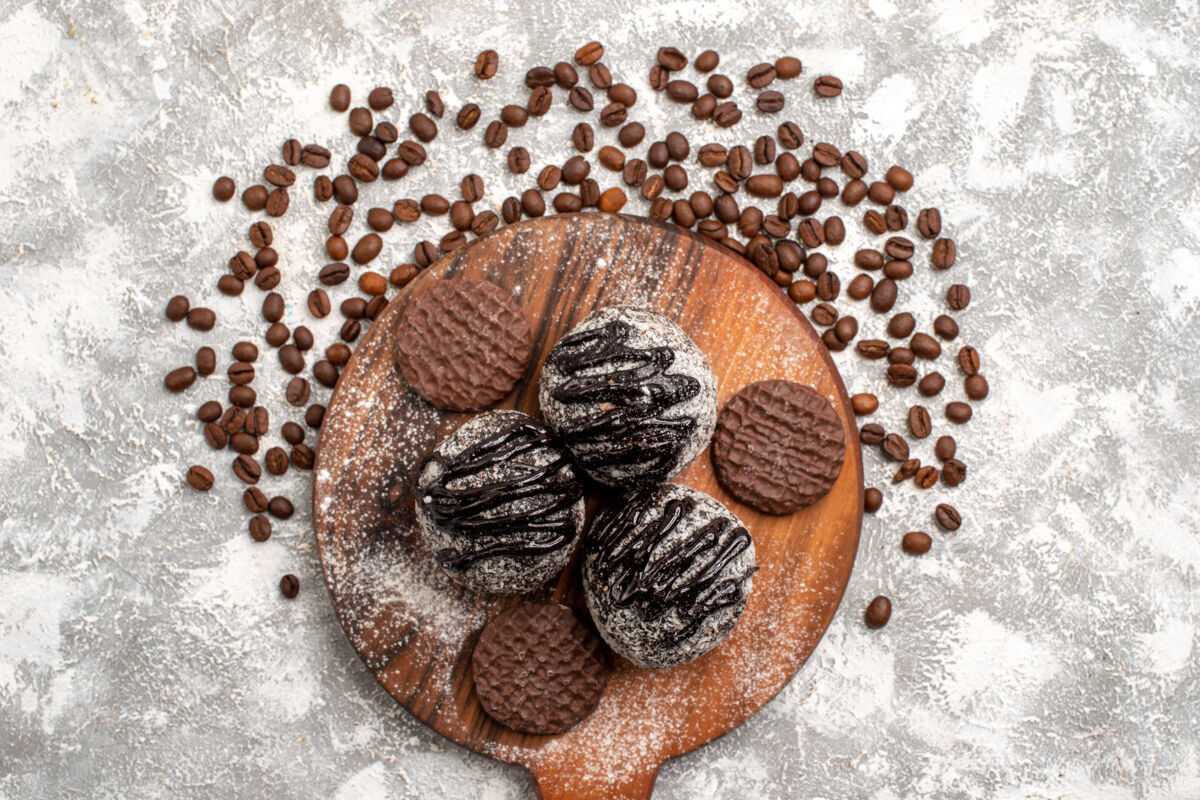 茶俯瞰美味的巧克力蛋糕 白色表面有饼干和咖啡籽水果食用坚果饼干