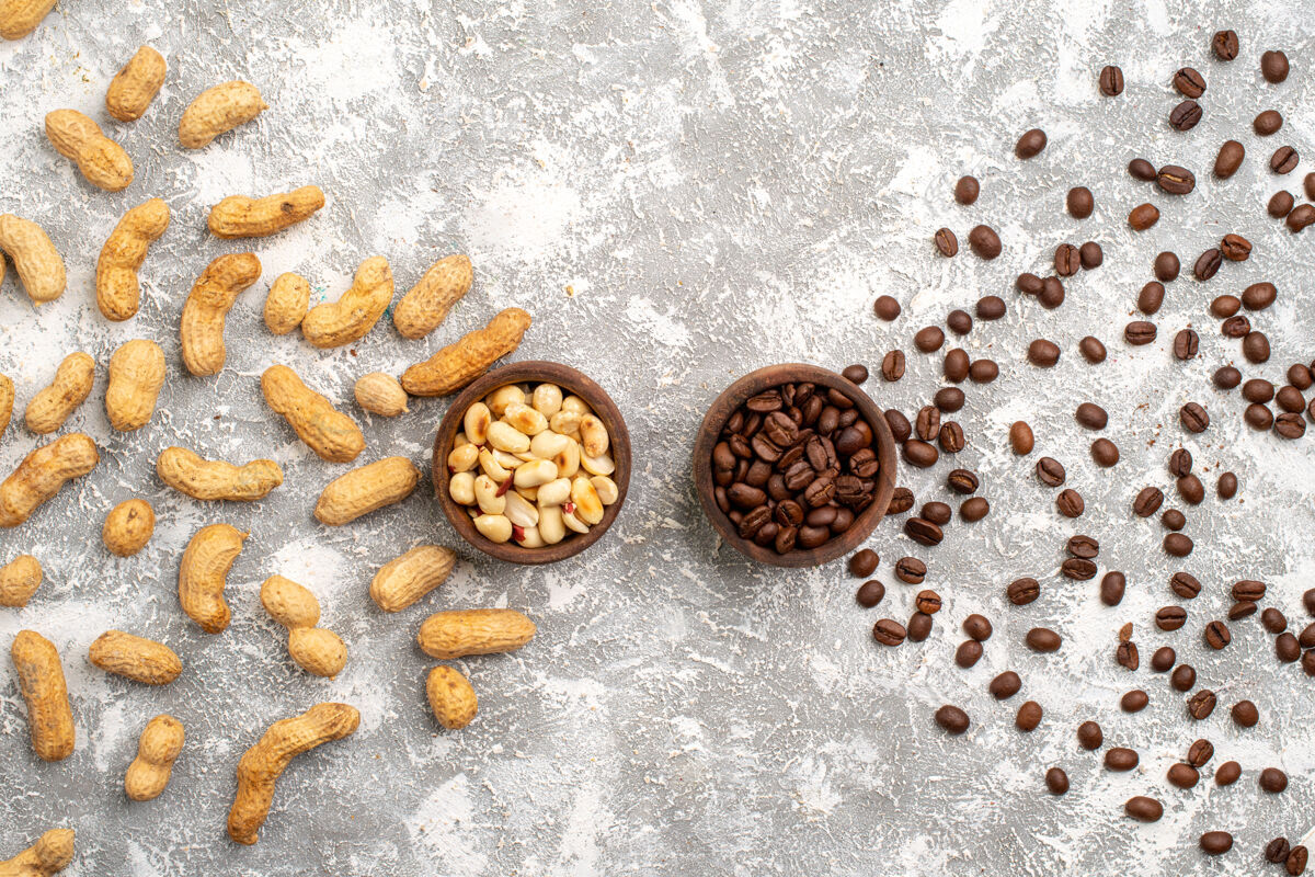 零食白色表面上有棕色咖啡籽的美味花生俯视图种子质地早餐