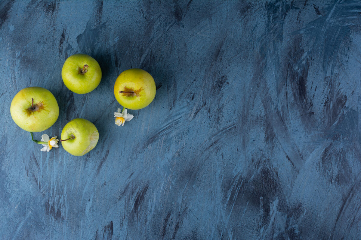 新鲜的美味的新鲜青苹果放在蓝色的桌子上完整的健康有光泽