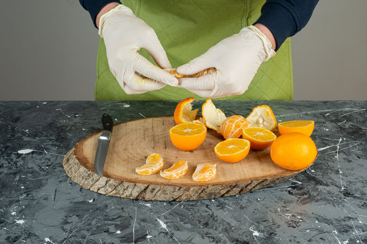 橙子男人戴着手套 手里拿着几片橘子放在桌上手准备各种