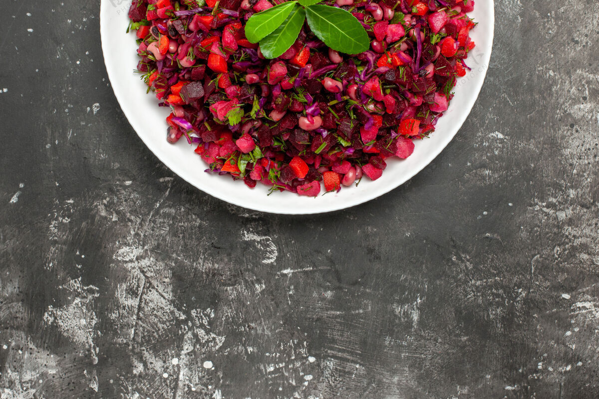 浆果在灰色背景上的左侧蔬菜沙拉的俯视图配料香料蔓越莓