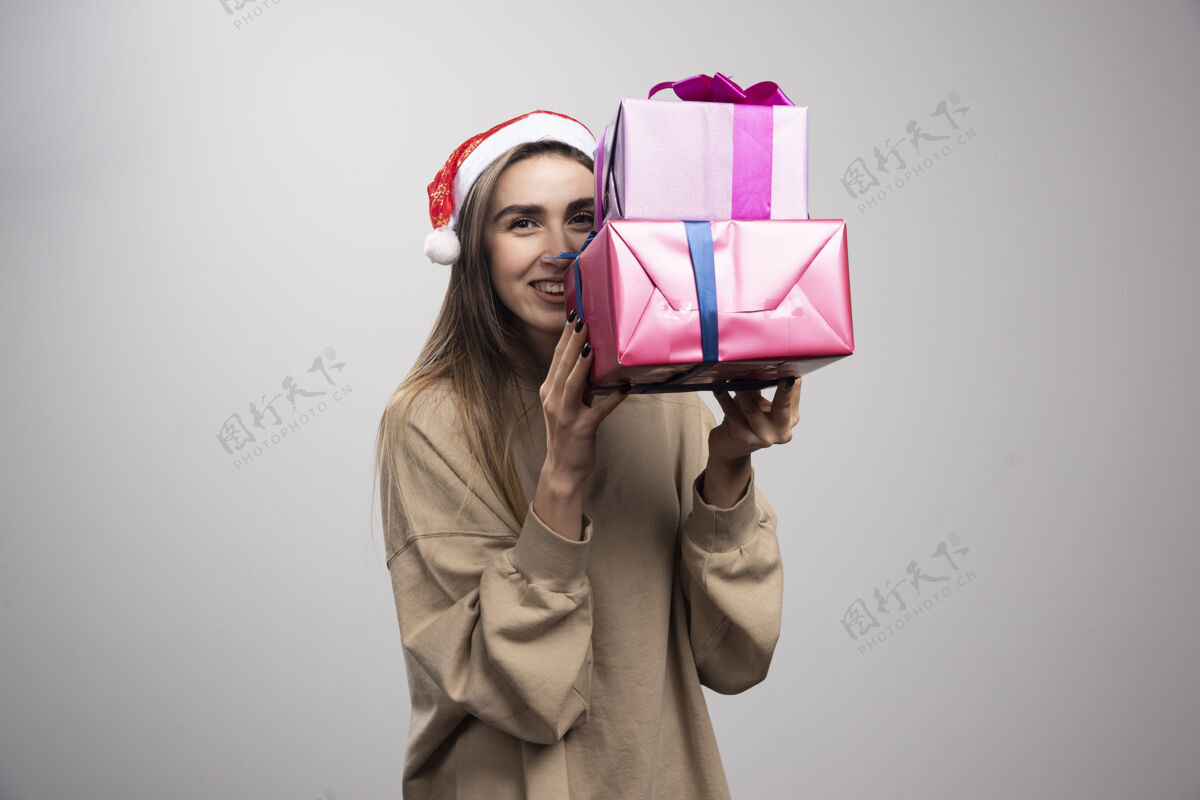 人年轻女子拿着两盒圣诞礼物礼物圣诞节成人