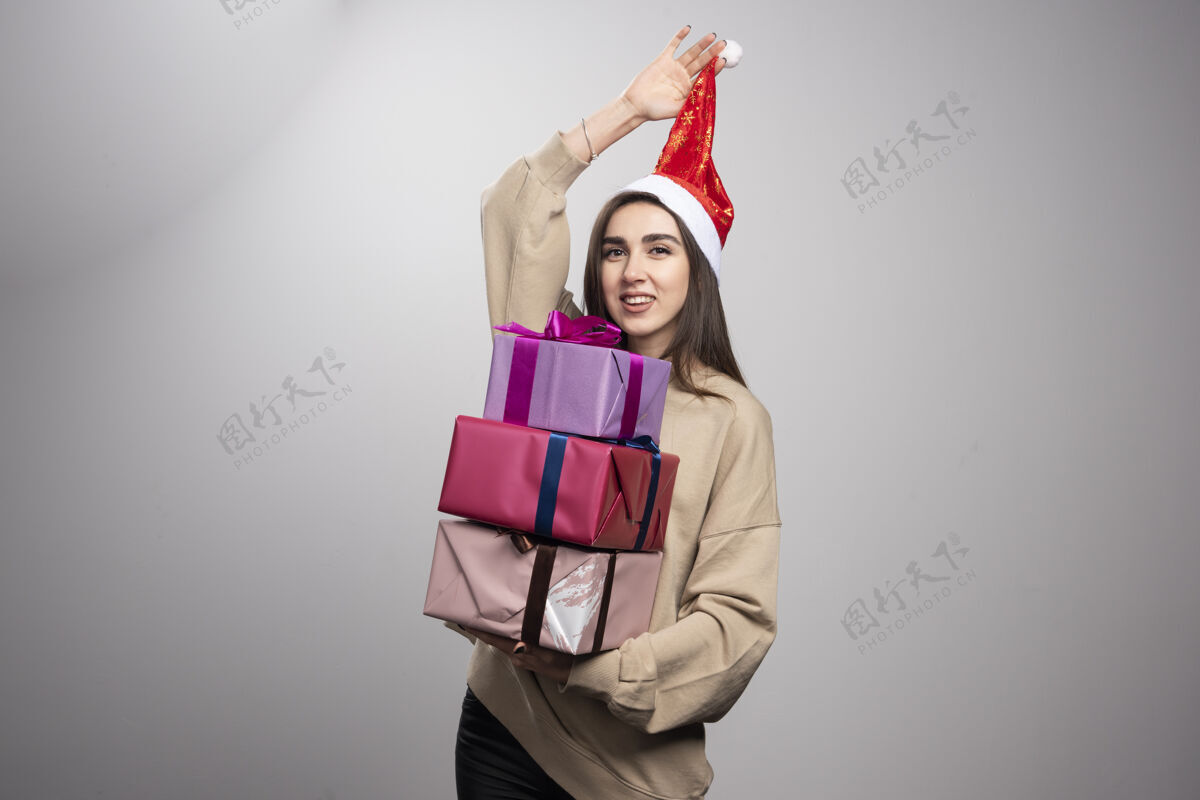 兴奋年轻女子拿着三盒圣诞礼物盒子红色女性