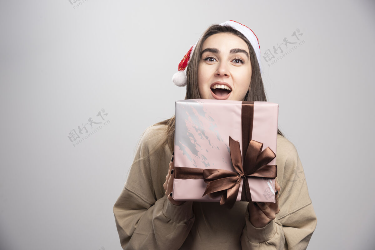 人年轻女子为一盒圣诞礼物兴奋不已漂亮携带礼物