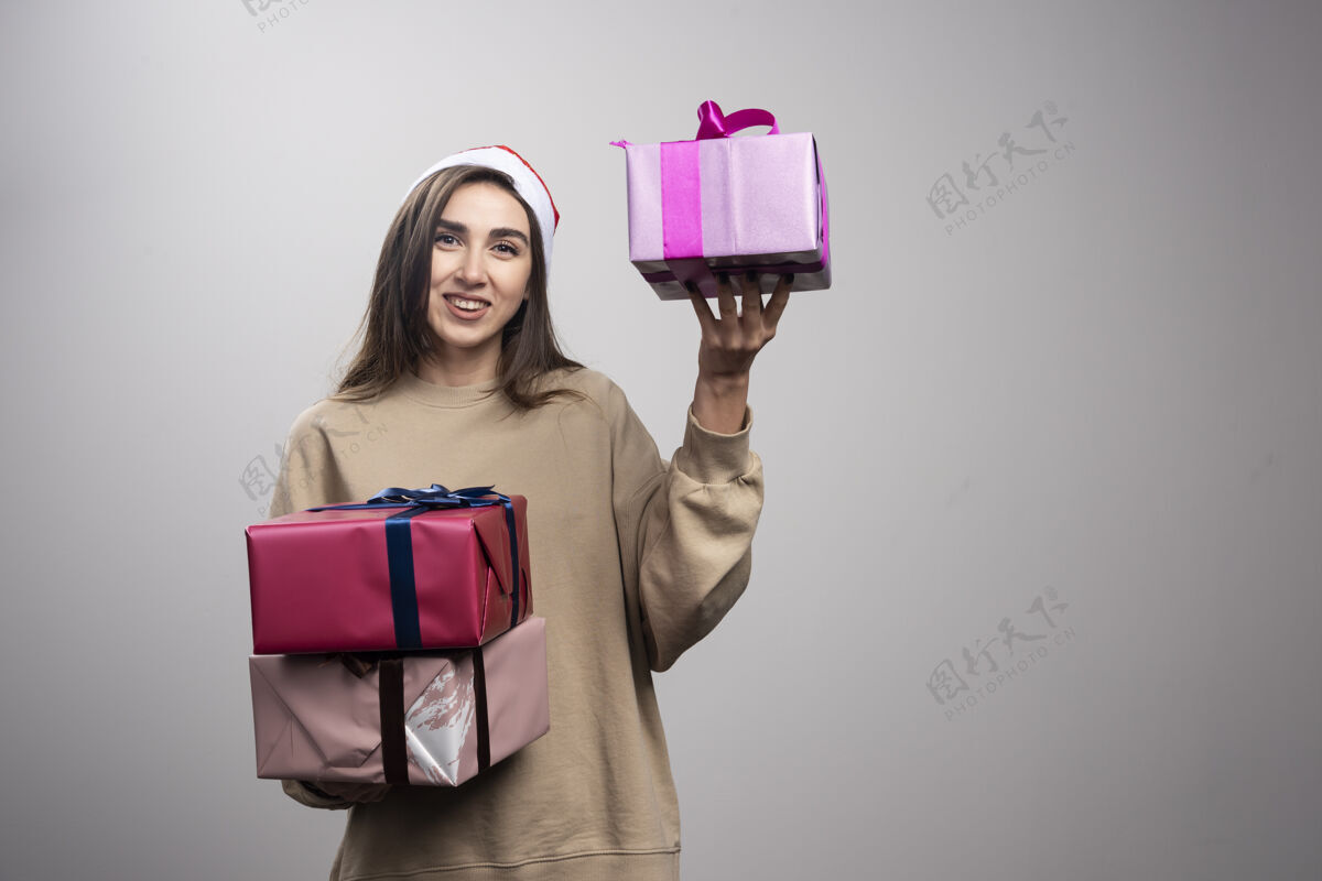 圣诞节年轻女子手里拿着三盒圣诞礼物年轻人圣诞老人