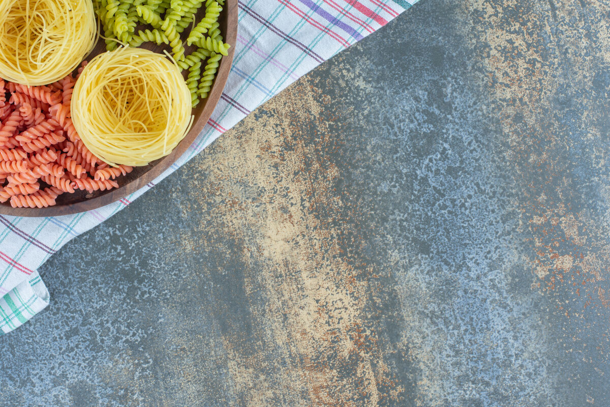 美味红色和绿色的意大利面和薄意大利面放在碗里的毛巾上 大理石背景上毛巾意大利面生的