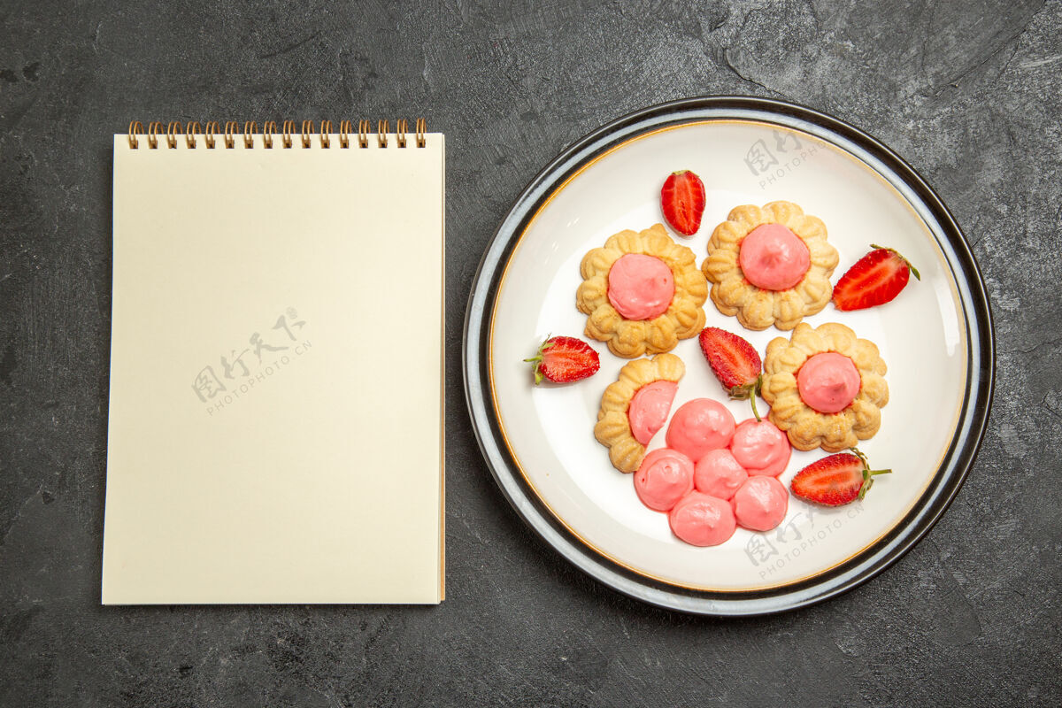 食物顶视图美味的小饼干与粉红色奶油内板在灰色的表面奶油美味的小饼干营养品