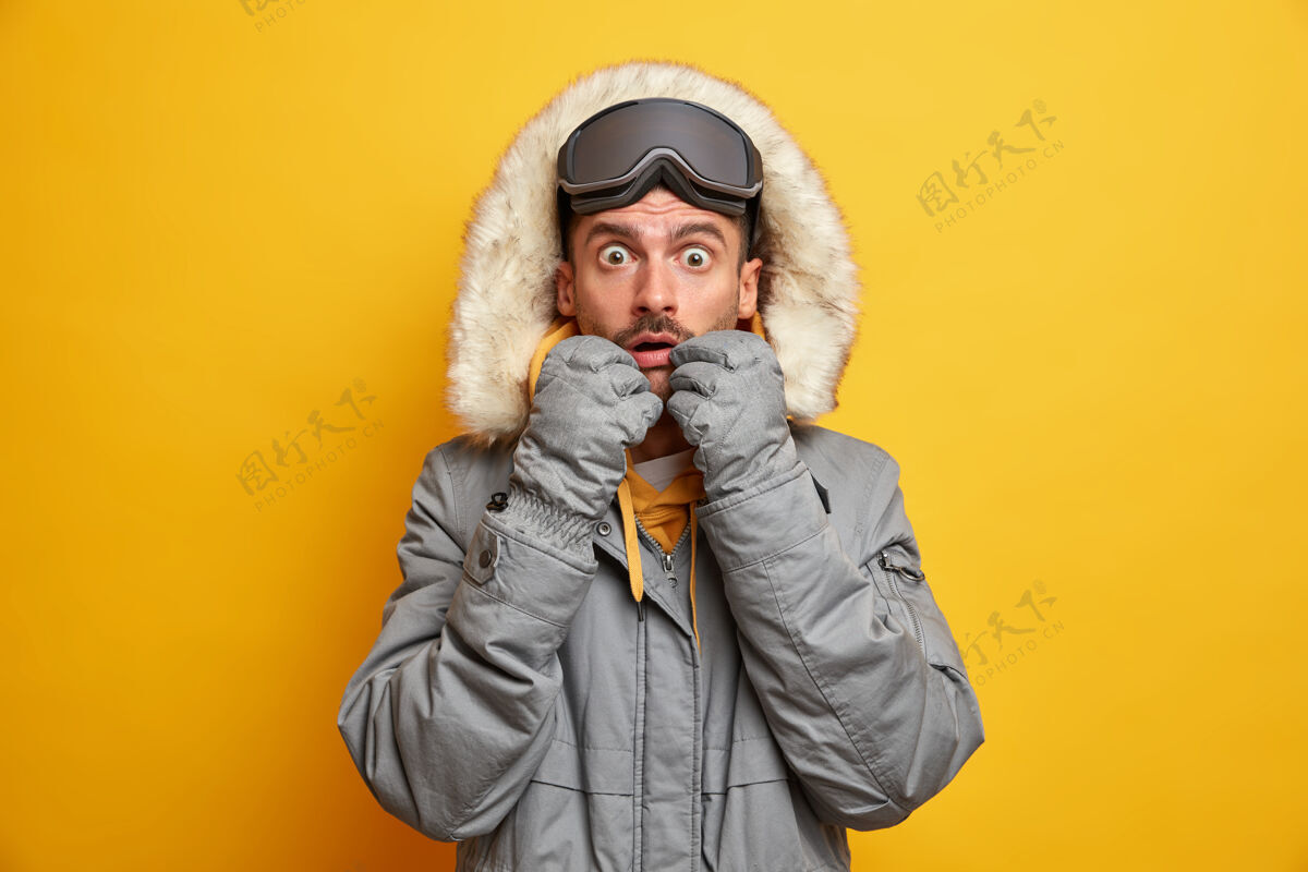白种人目瞪口呆的白人成年男子盯着被窃听的眼睛穿着保暖的衣服为寒冷季节滑雪护目镜享有最喜爱的爱好和积极的休息人物欧洲兜帽