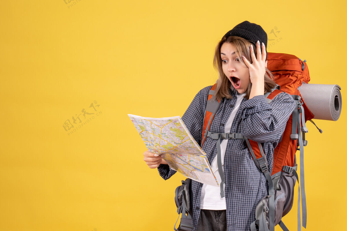 人前视图惊奇的旅行妇女背着背包看地图和服衣服女士