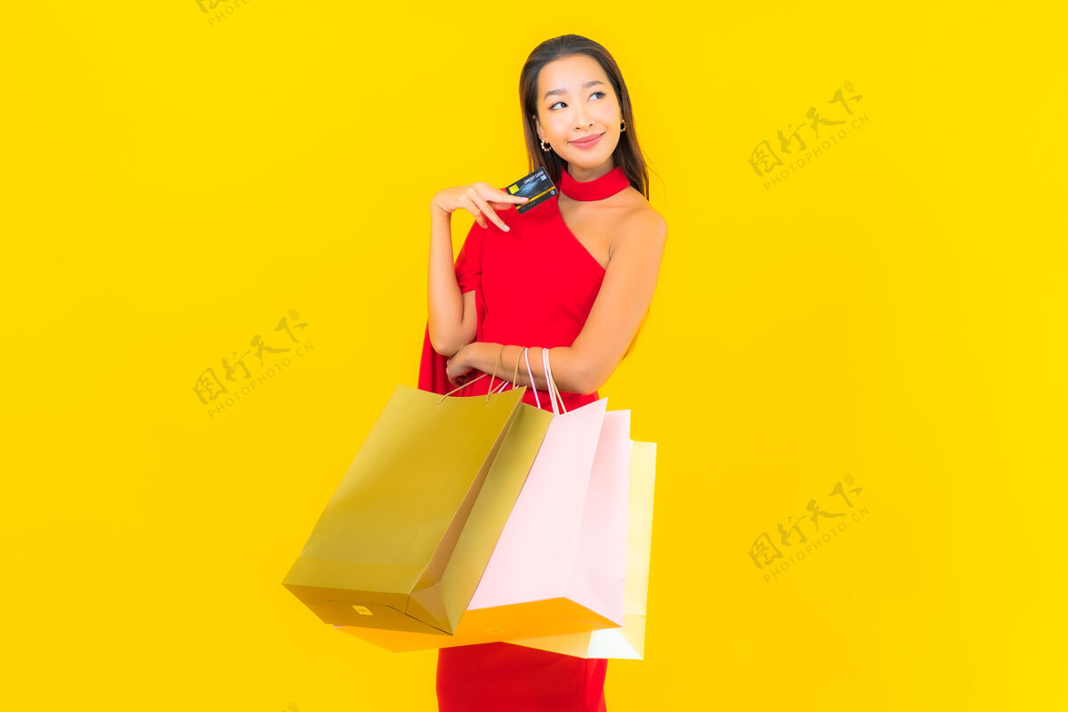 女士带购物袋和信用卡的美丽亚洲年轻女子肖像付款泰国微笑
