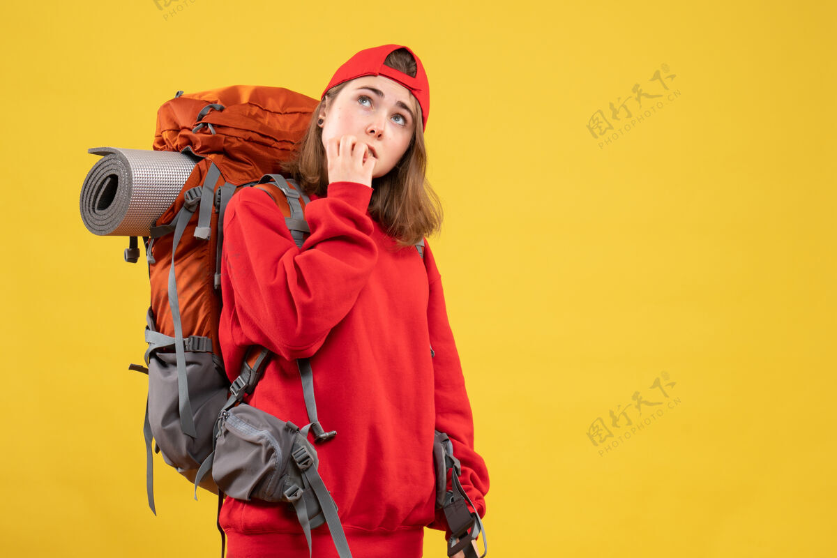 时尚正面图很酷的女旅行者背着背包在想什么成人人帽子