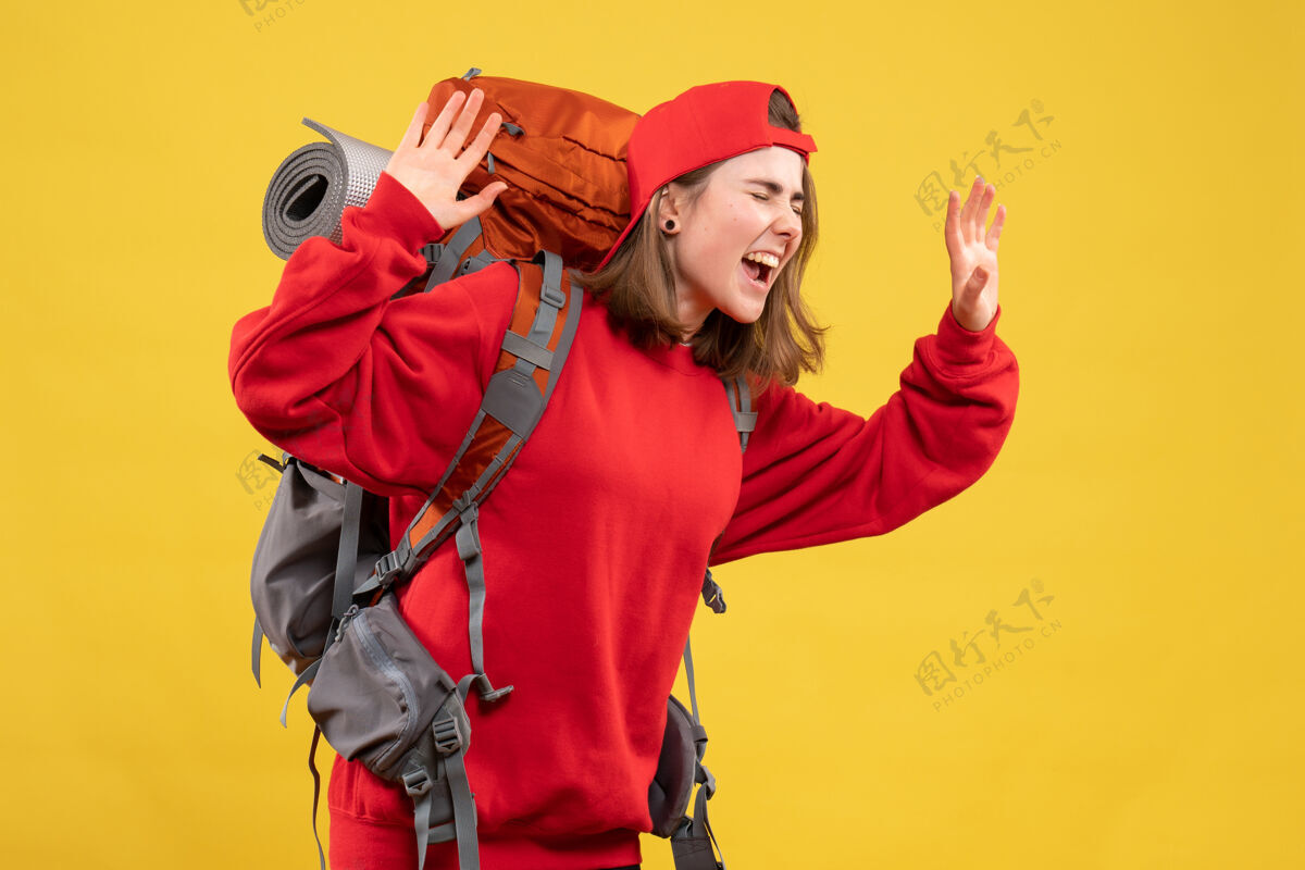 人正面图酷酷的女旅行者 背着背包表达自己的感受乐趣成人快乐