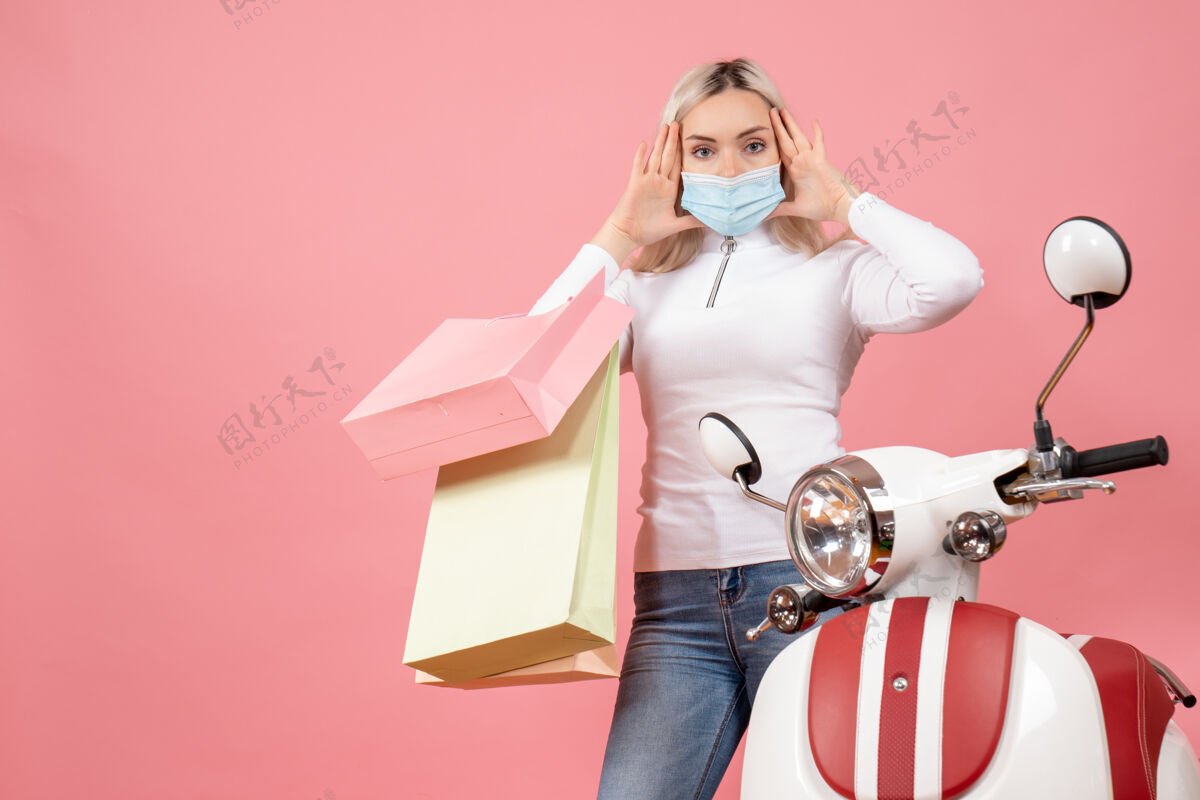轻便摩托车前视图困惑的年轻女士拿着购物袋附近的轻便摩托车成人摄影师时尚