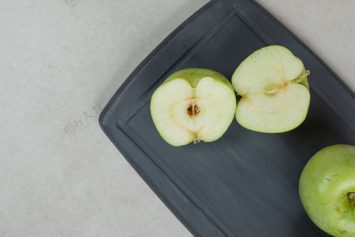 有机在深色的盘子上切一整块半的青苹果水果可口食品