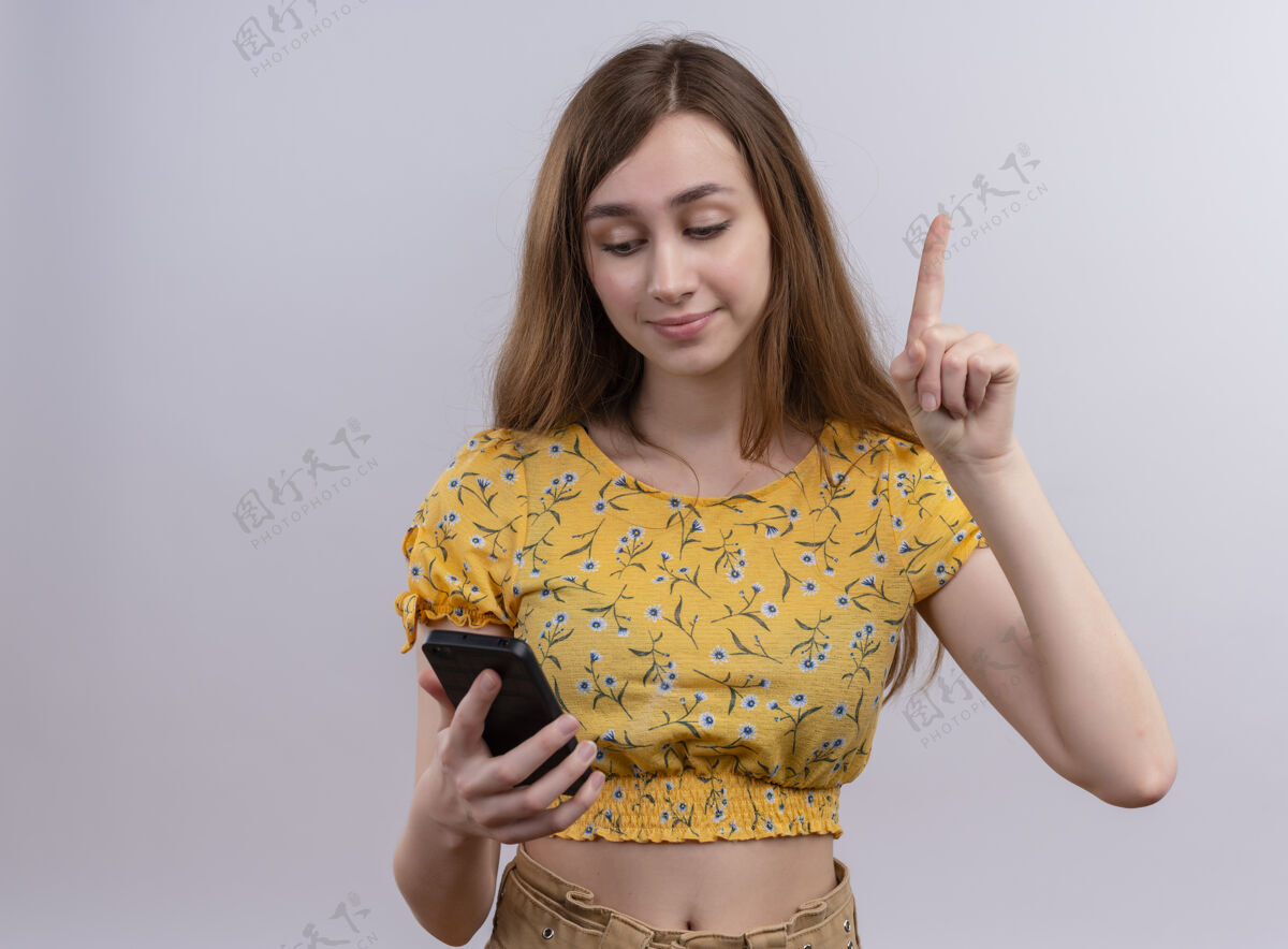 年轻印象深刻的年轻女孩举起手指拿着手机 看着手机与复制空间手指提高手机