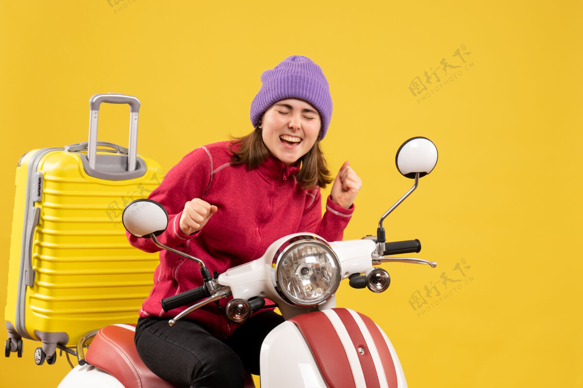 人前视图骑着轻便摩托车的快乐年轻女子摩托车前面微笑